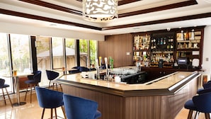 A modern bar area with a central island, bar stools, and a well-stocked liquor shelf.