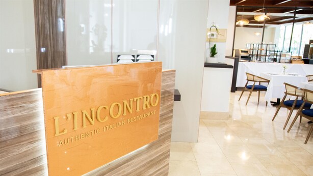 A reception area with a sign reading "L'INCONTO Authentic Italian Restaurant."