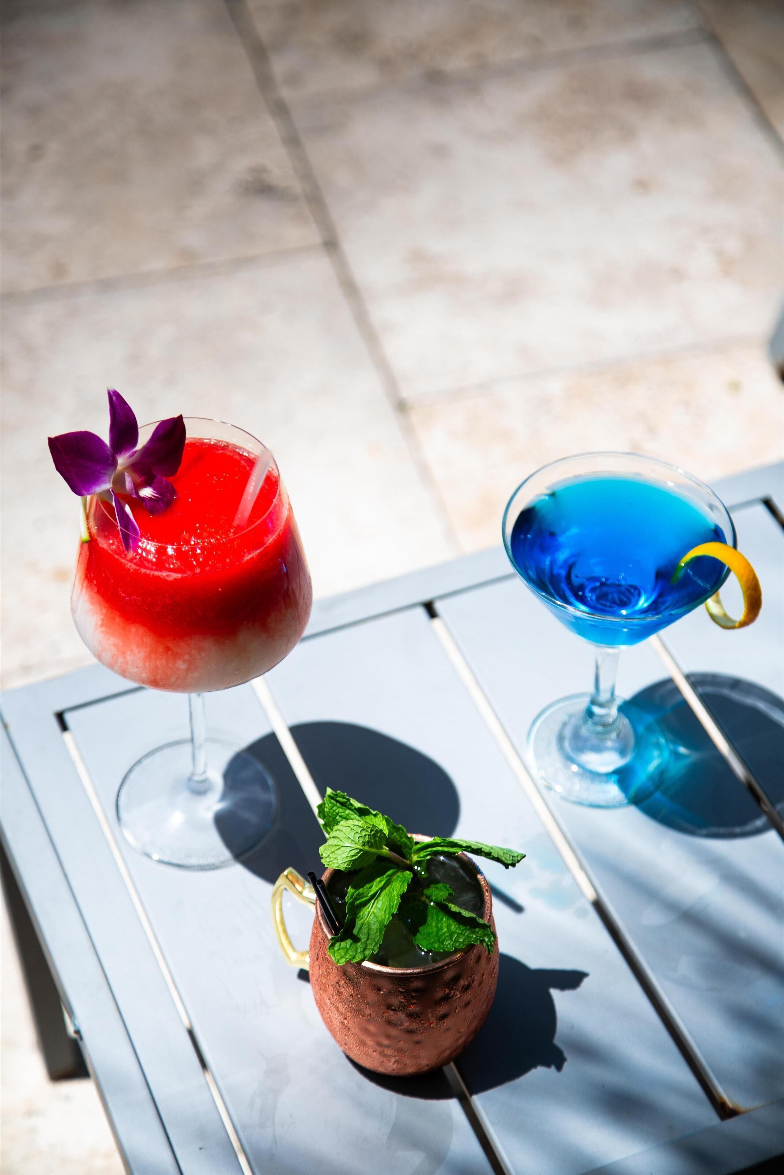 Dos bebidas sobre una mesa, con una jarra de vidrio que contiene una bebida y hojas de menta.