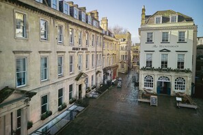 Una stretta via fiancheggiata da edifici storici, tra cui l'Abbey Hotel e The Huntsman.