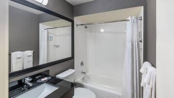 Un baño moderno con lavamanos, inodoro y ducha.