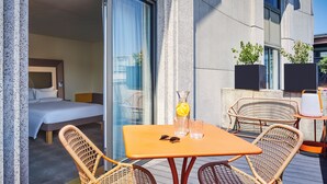 A hotel room with a bed, a small table with chairs, and a window with curtains. - Novotel Paris Gare De Lyon (Paris)
