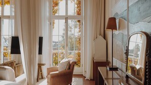 Une pièce avec une grande fenêtre, une chaise, une lampe et un miroir.