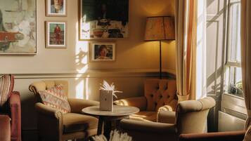 A cozy living room with a sofa, armchair, and a small table with a decorative item.