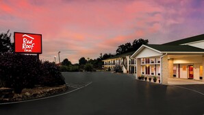A Red Roof Inn with a parking lot and a building with a green roof. - Red Roof Inn Monteagle - I-24 (Monteagle)