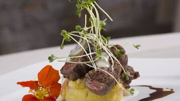 Un plat composé de viande, de purée de pommes de terre et d’une garniture de jeunes pousses.