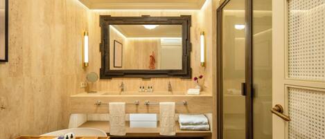 Un baño moderno con tocador de madera, un espejo grande y cabina de ducha de vidrio.