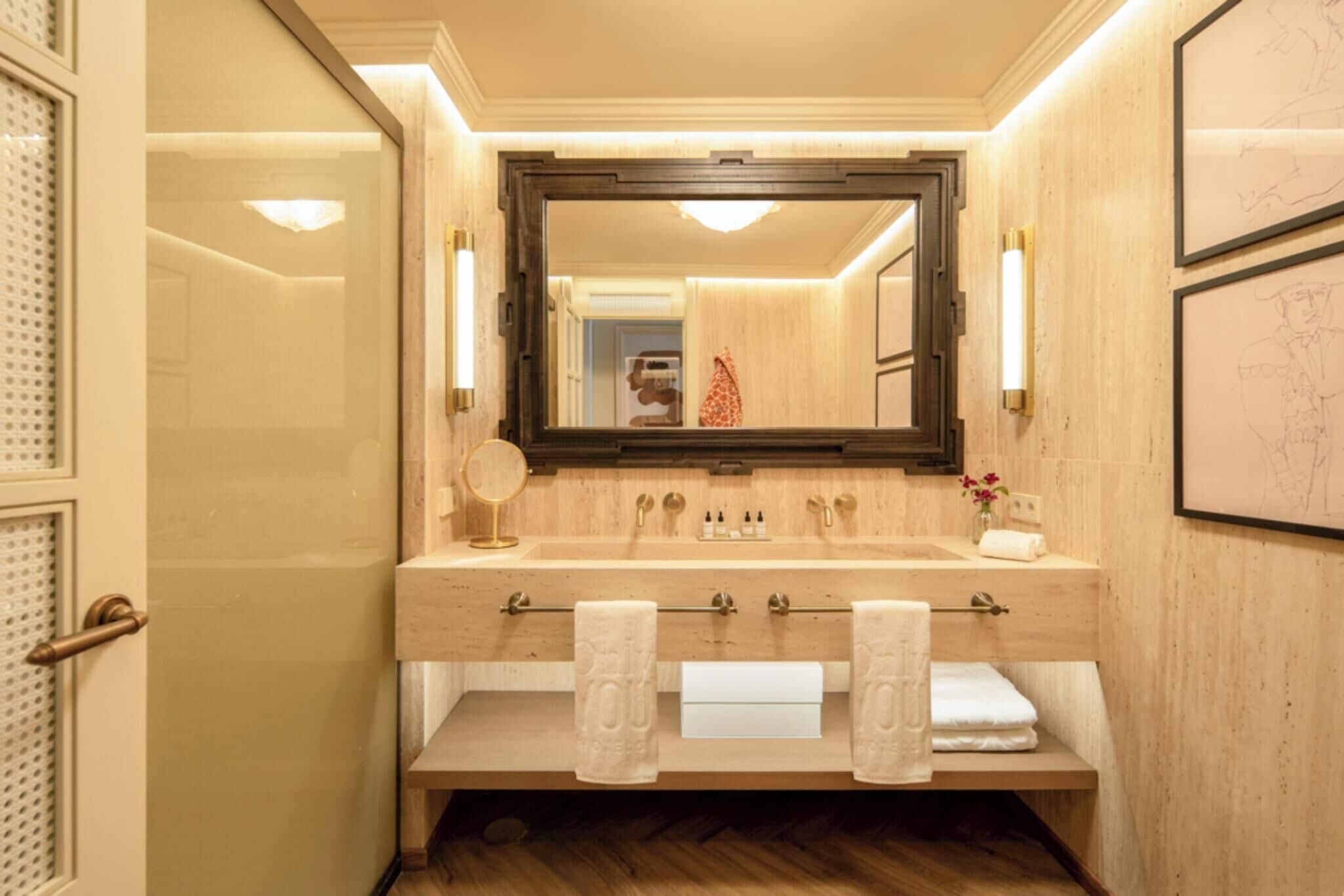 A bathroom with a wooden vanity, a large mirror, and two sinks.