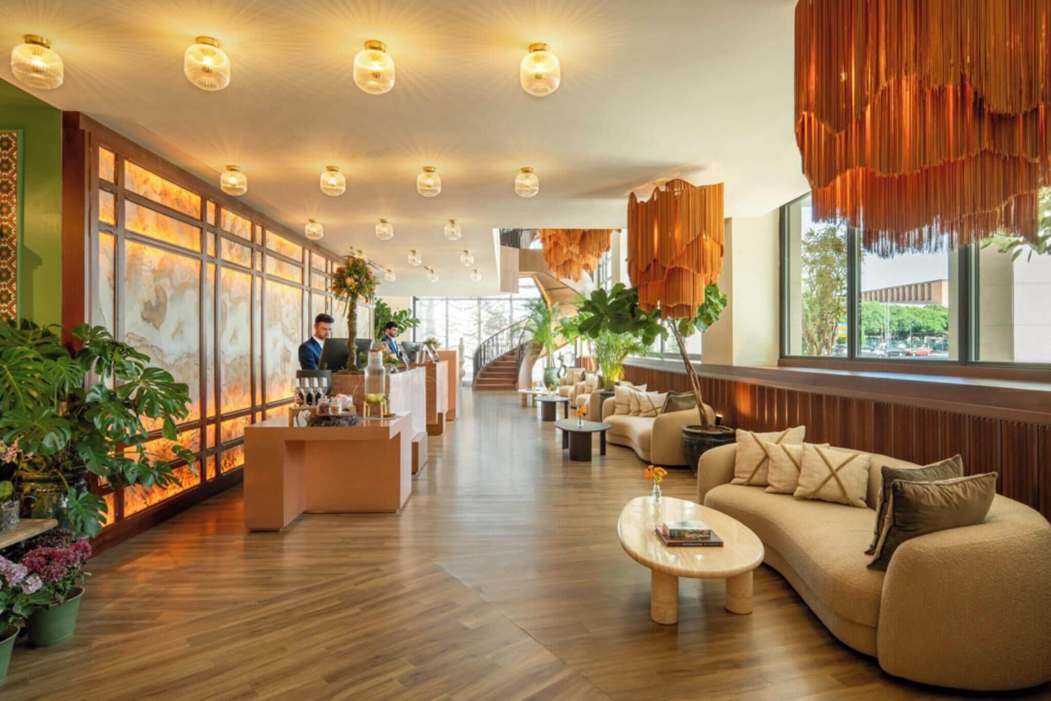 Eine geräumige Lobby mit Empfangsschalter, Sitzbereich und einer Treppe zu den oberen Etagen.