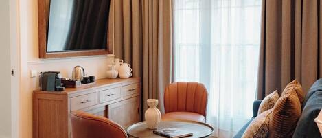 Een moderne woonkamer met een flatscreen televisie, een bank, een salontafel en een open haard.