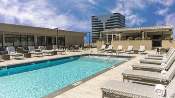 Alberca al aire libre, sombrillas en la alberca y camastros