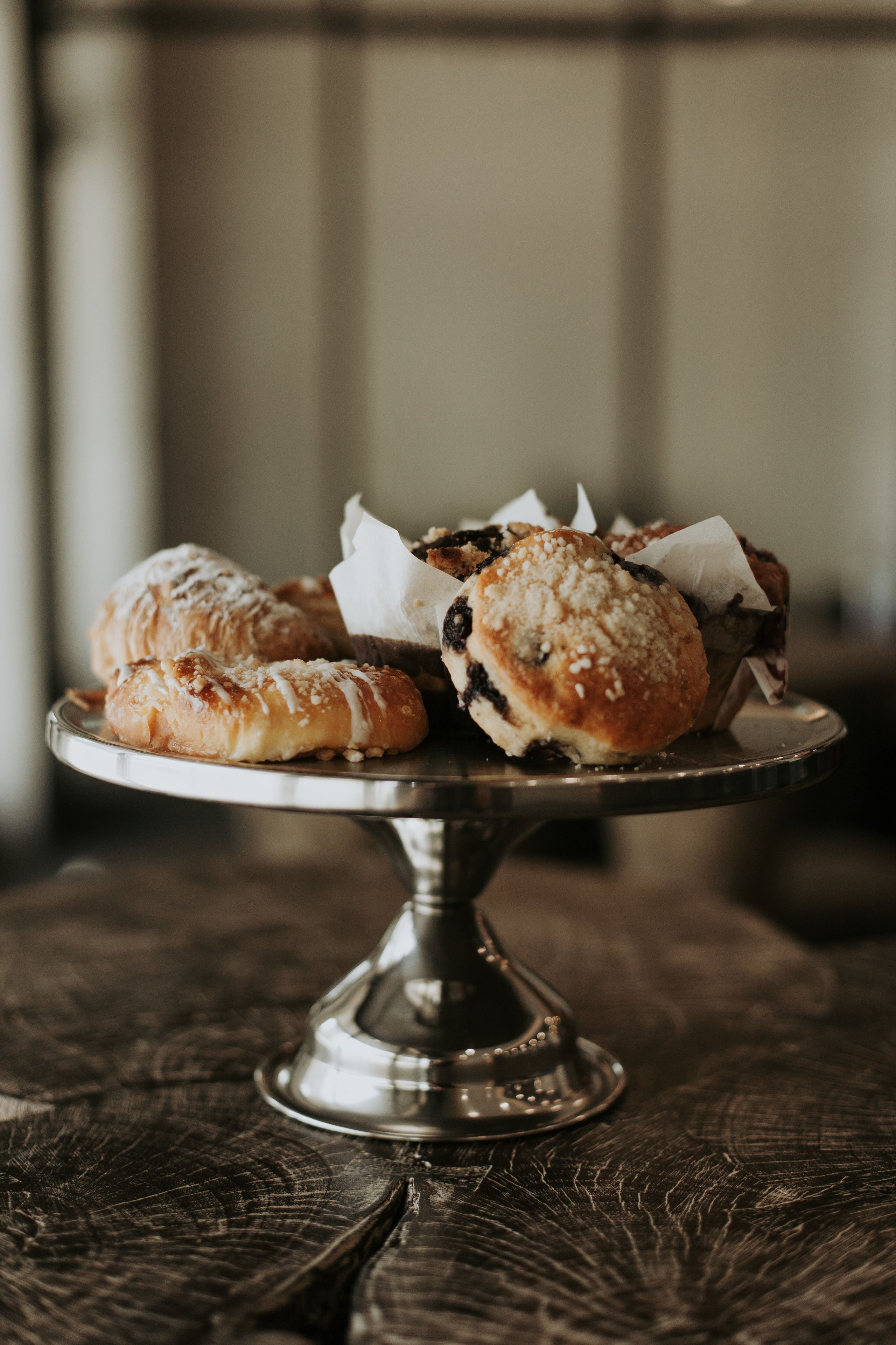 A metal cake stand with pastries on it.