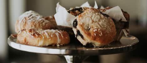 A metal cake stand with pastries on it.