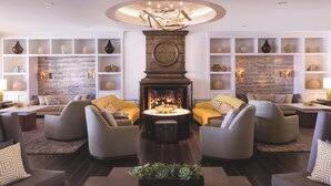 A modern living room with a fireplace, comfortable seating, and decorative shelves. - The Ritz-Carlton, Marina del Rey (Marina del Rey)