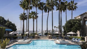 A pool area with lounge chairs and palm trees. - The Ritz-Carlton, Marina del Rey (Marina del Rey)