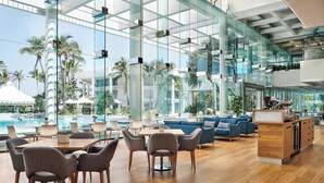 A spacious lobby with a pool view, modern furniture, and a kitchen area. - Sheraton Grand Mirage Resort, Gold Coast (Main Beach)