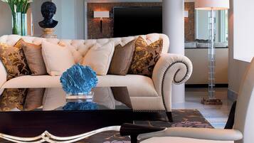 A modern living room with a tufted sofa, decorative pillows, a blue abstract sculpture, and a floor lamp.