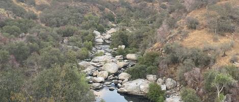 Un río serpentea por un paisaje montañoso, con terreno rocoso y vegetación escasa.