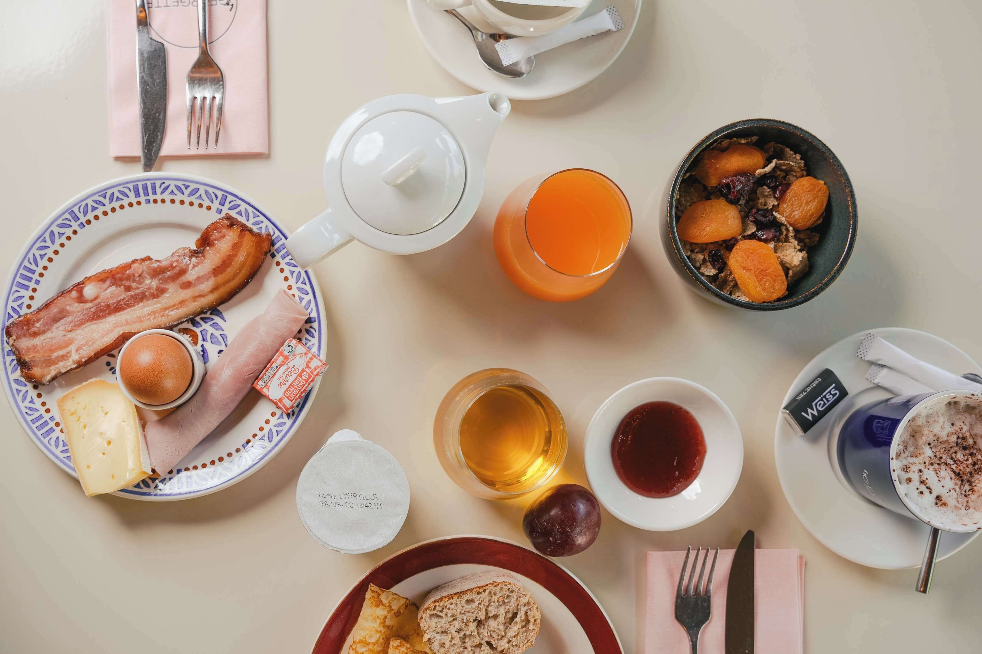 Una escena de desayuno con diversos alimentos y bebidas sobre una mesa.
