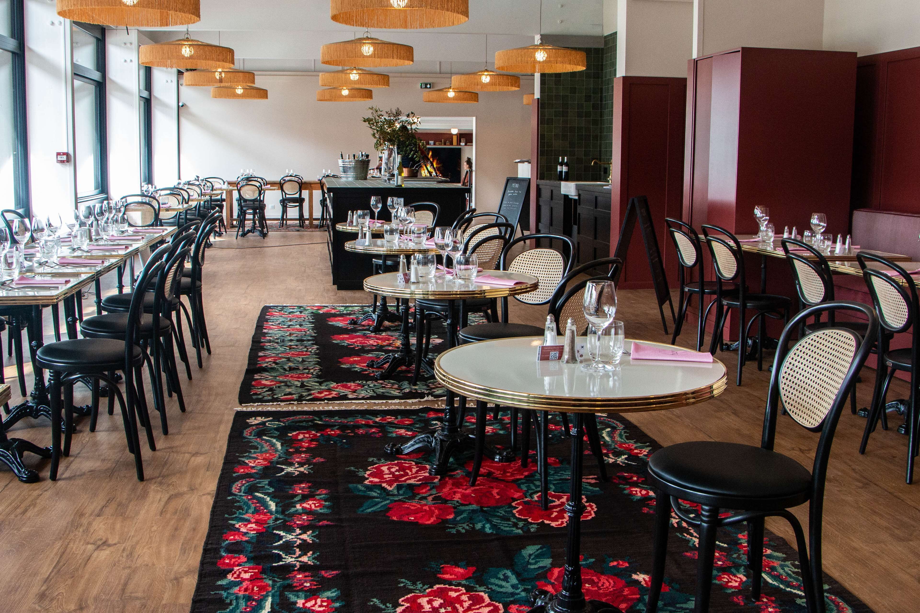 A restaurant with long communal tables, individual booths, and a bar area.