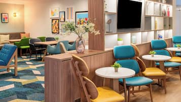Relax in a stylish lounge area with comfortable seating, a large flat-screen TV, and beautiful artwork.