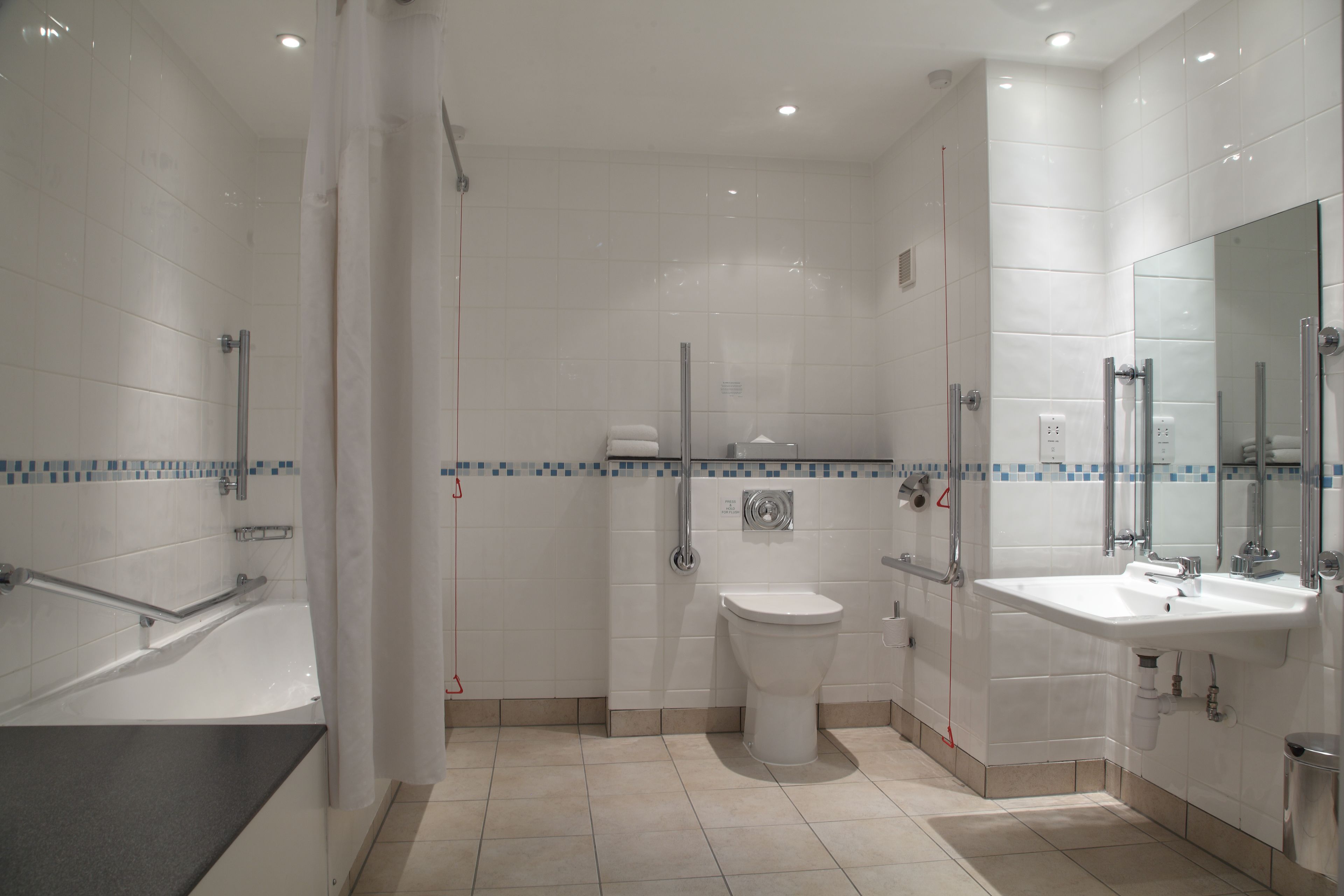A modern bathroom with a bathtub, toilet, and sink.