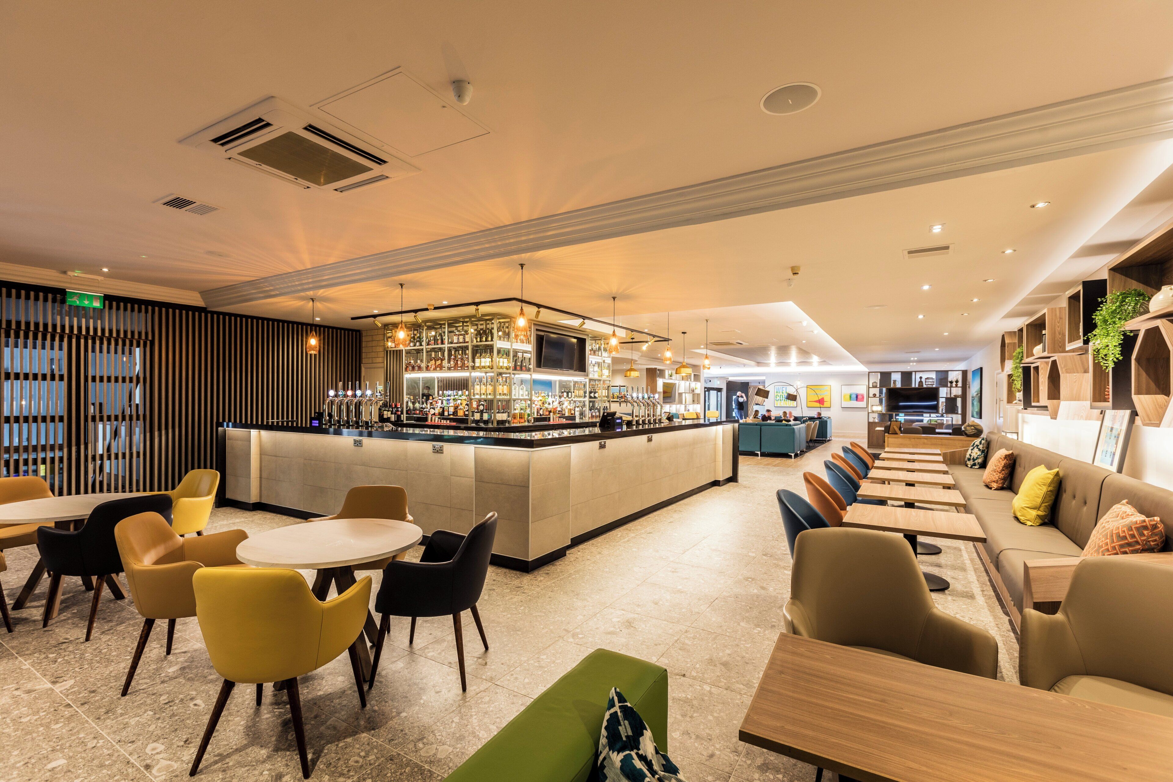 A modern bar area with seating and a bar counter.