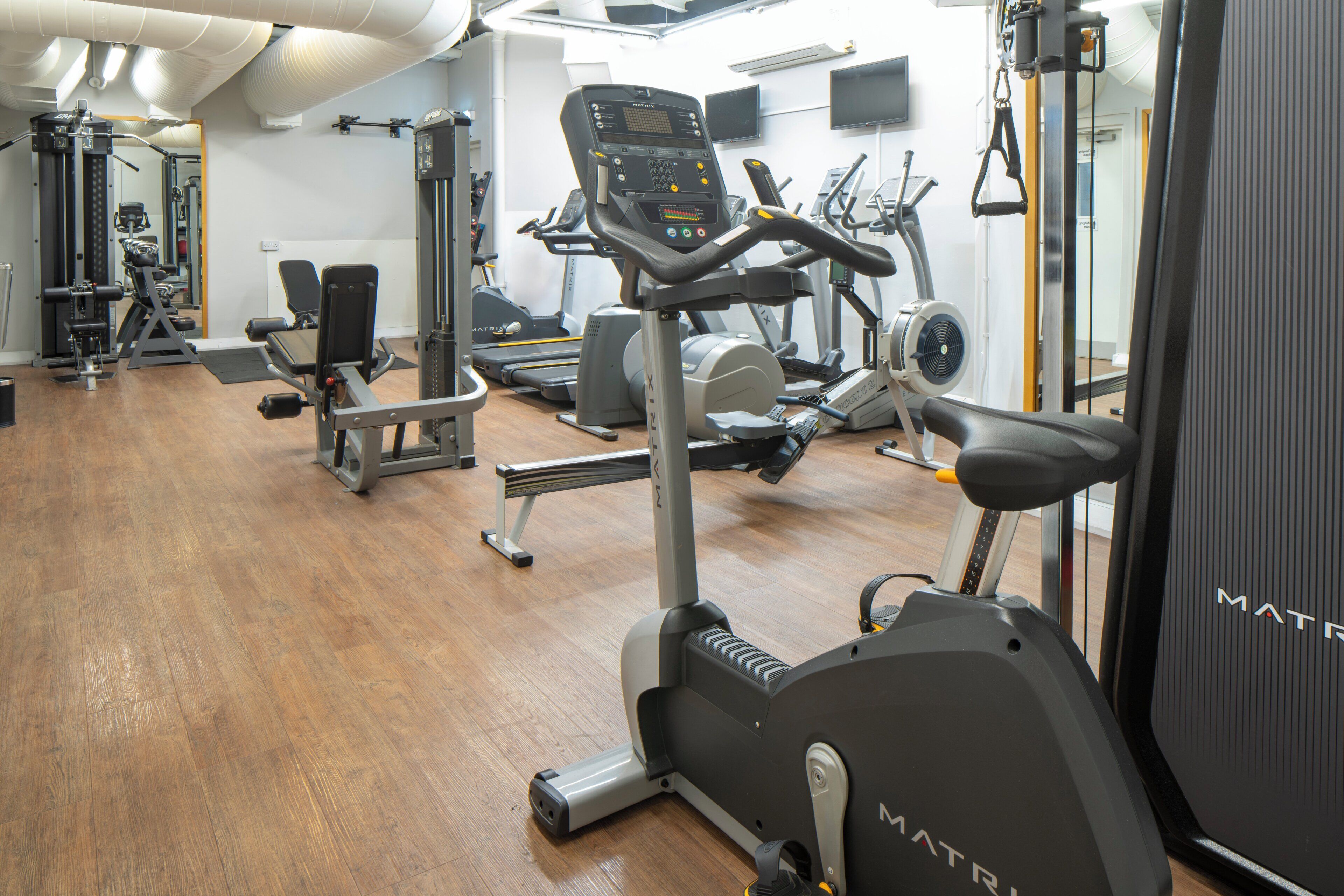 A gym with various exercise equipment, including treadmills and weight machines.
