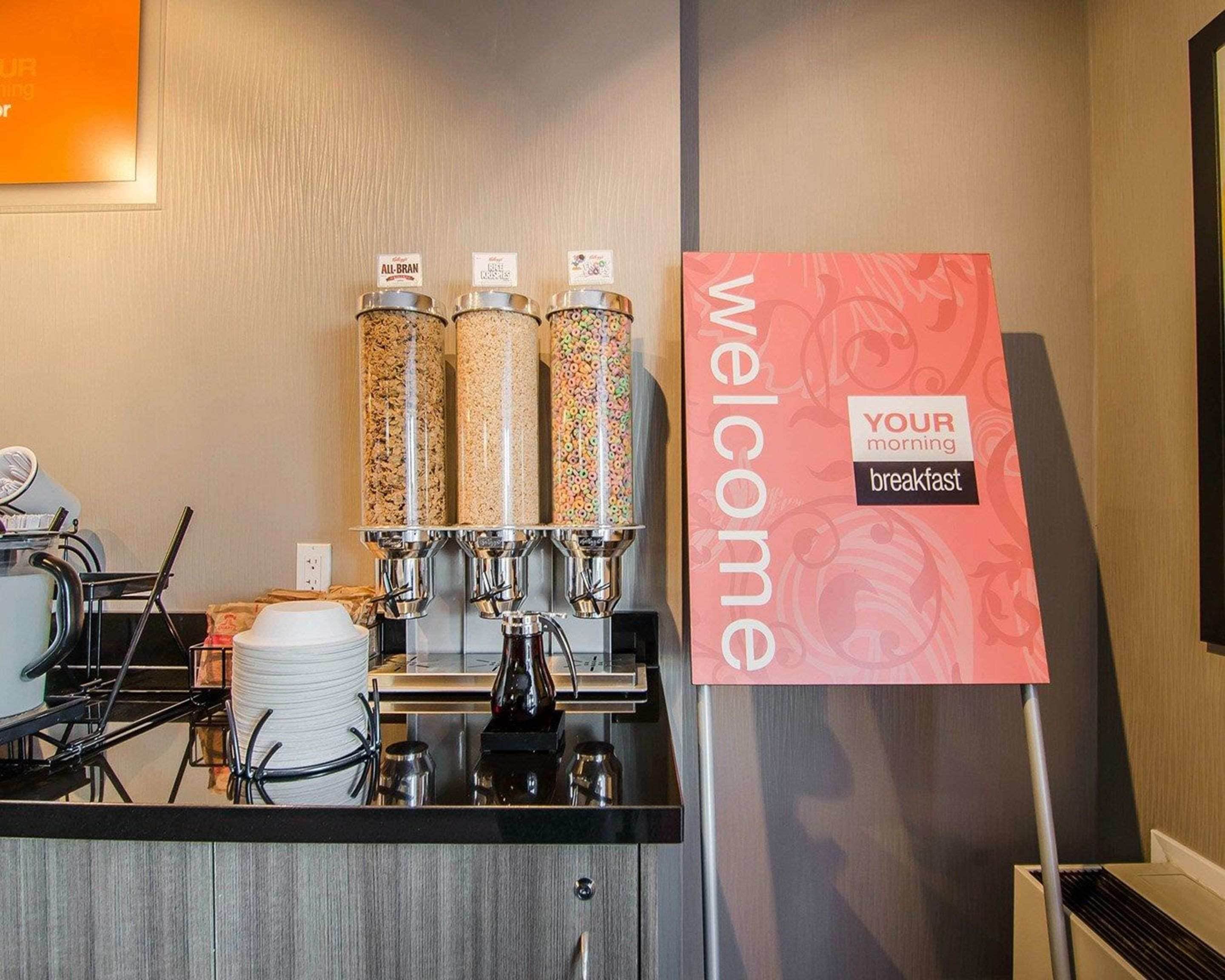 Un coin petit-déjeuner équipé de trois distributeurs, d’une pancarte sur laquelle est écrit « bienvenue » et d’une machine à café.