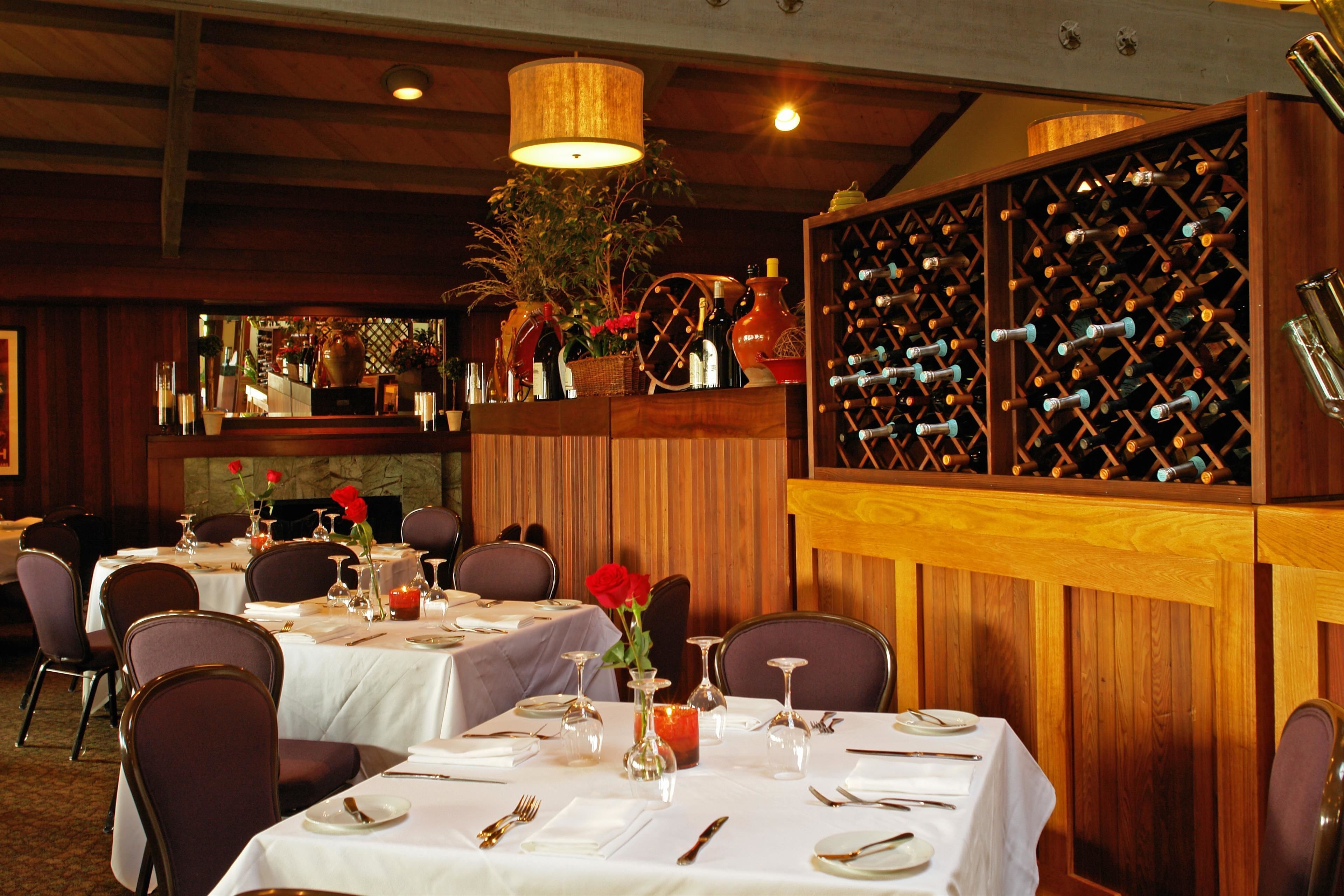 Un restaurante con varias mesas dispuestas para comer, una bodega y una zona de bar.