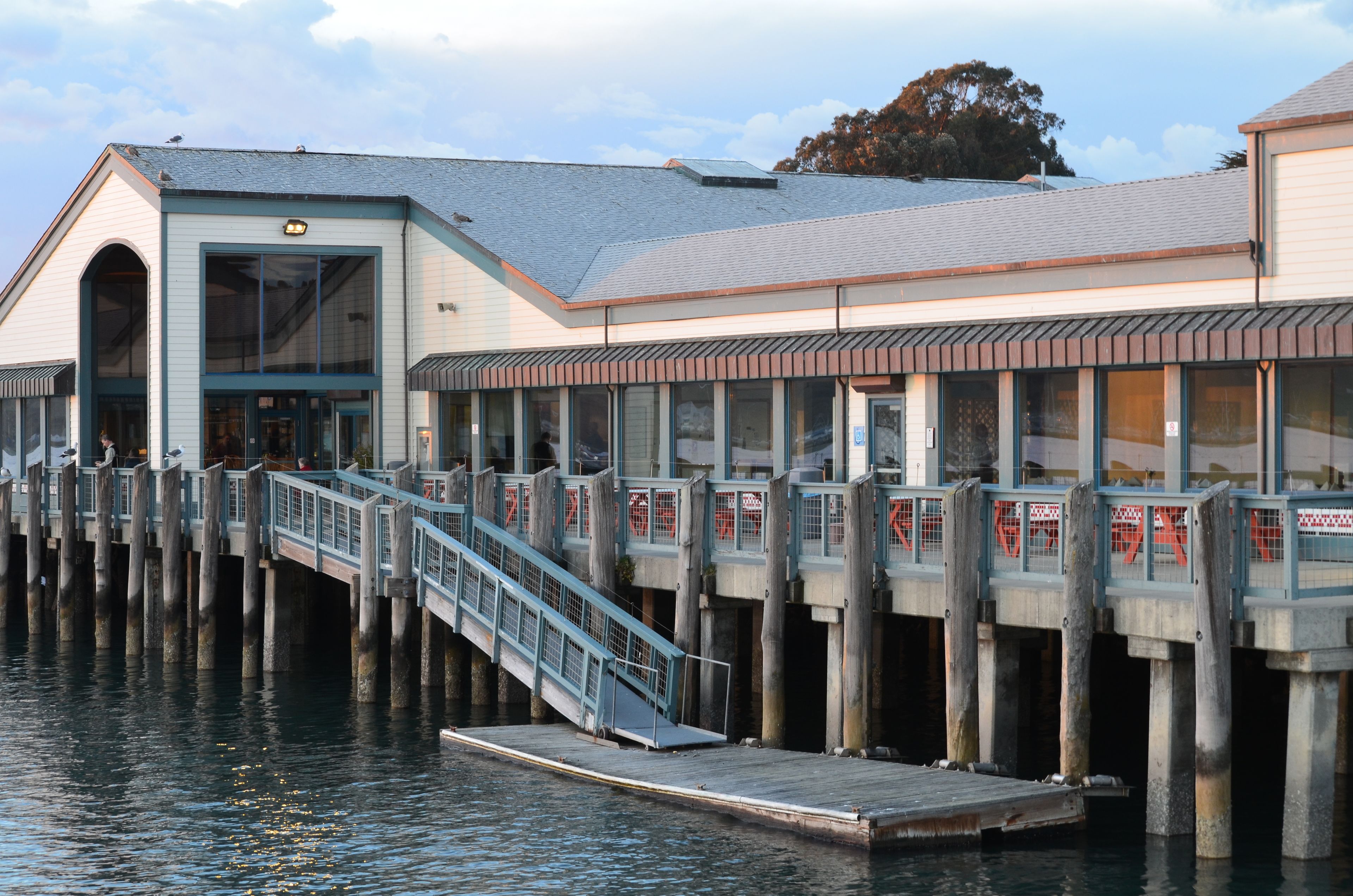 A waterfront building with a dock and a staircase leading to the entrance.