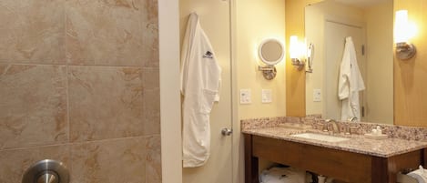 A bathroom with a bathtub, a sink, a mirror, and a towel rack.