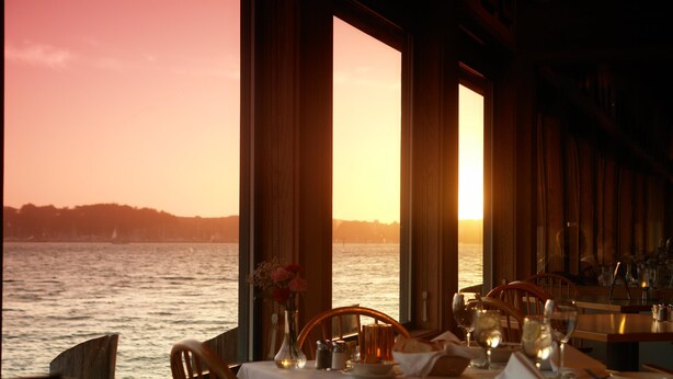 A table set for dining with a view of the ocean at sunset. - The Inn at the Tides (Bodega Bay)