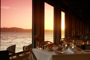A table set for dining with a view of the ocean at sunset. - The Inn at the Tides (Bodega Bay)