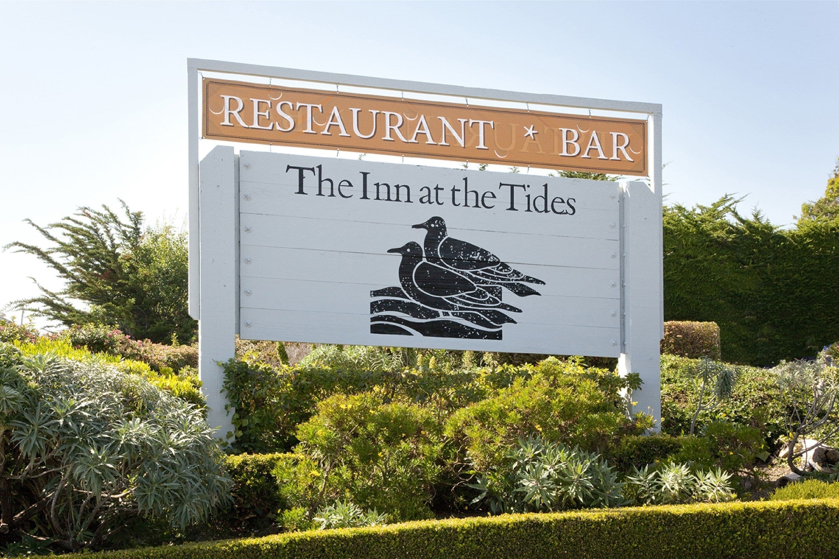 Letrero del restaurante y bar 'The Inn at the Tides', con una ilustración de un pájaro.
