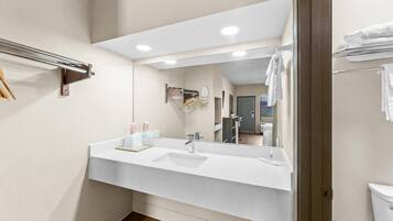 Une salle de bain avec un lavabo blanc, un miroir et un porte-serviettes.