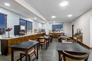 Une cuisine moderne dotée d’un long comptoir, de divers appareils électroménagers et d’un espace repas.