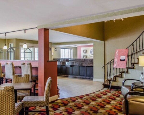 Rebedor d'hotel amb zona de dinar, cuina al fons i una escala.
