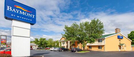 A Baymont by Wyndham hotel with a parking lot and several cars parked.