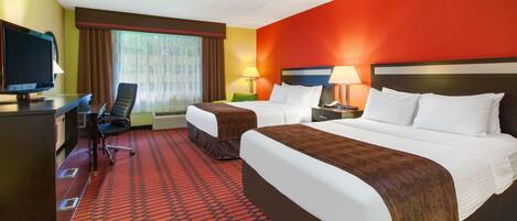 A hotel room with two beds, a desk with a television, and a chair.