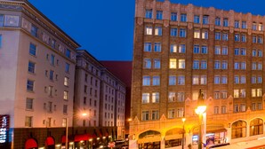 A multi-story hotel with a classic architectural design, featuring a prominent entrance with arched windows and a well-lit facade. - The Pickwick Hotel (San Francisco)