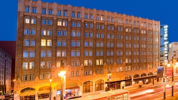 A large, multi-story hotel with a classic architectural style, featuring numerous windows and a prominent entrance with arched windows.