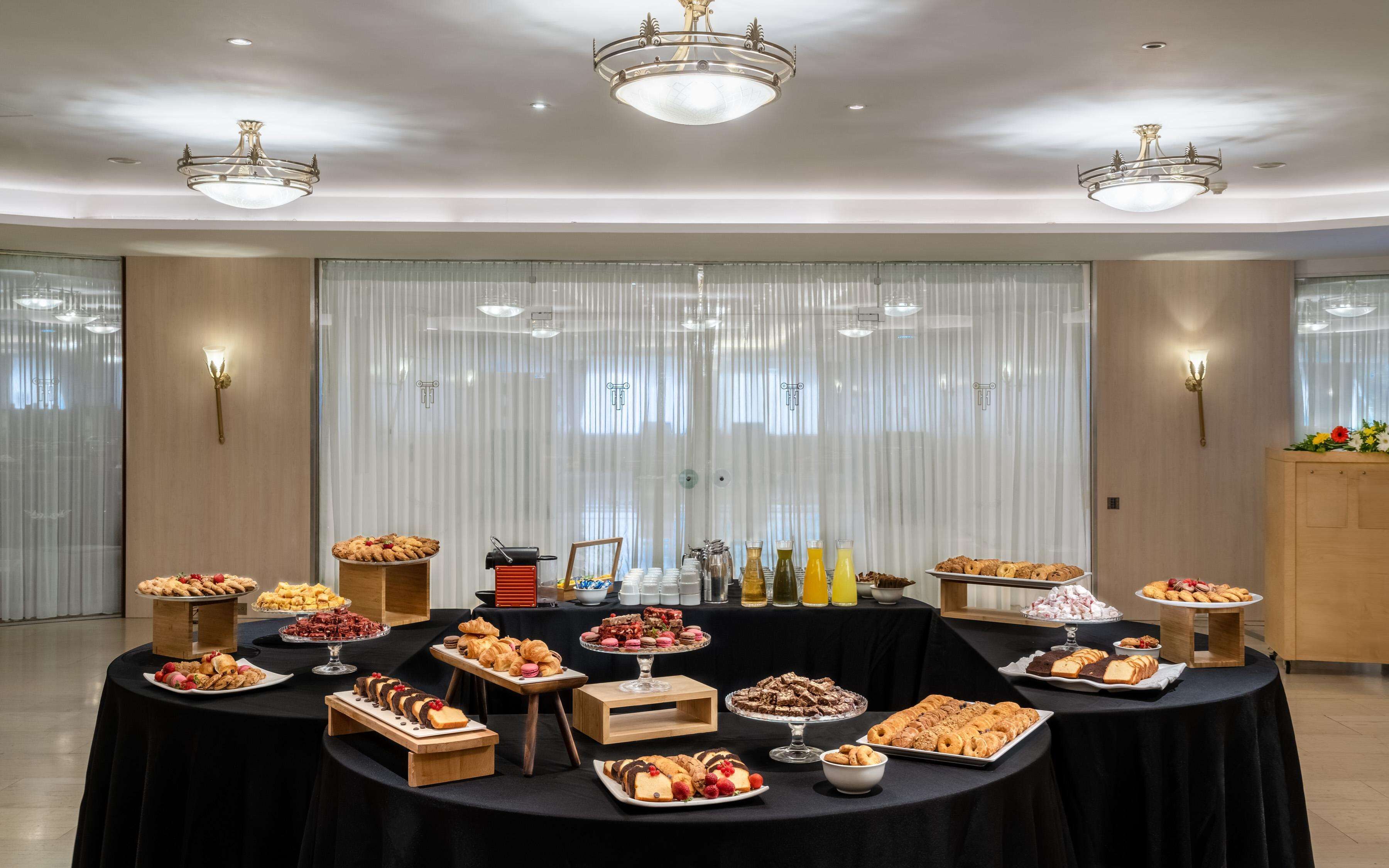 Una mesa de buffet con diversos alimentos y una lámpara decorativa.