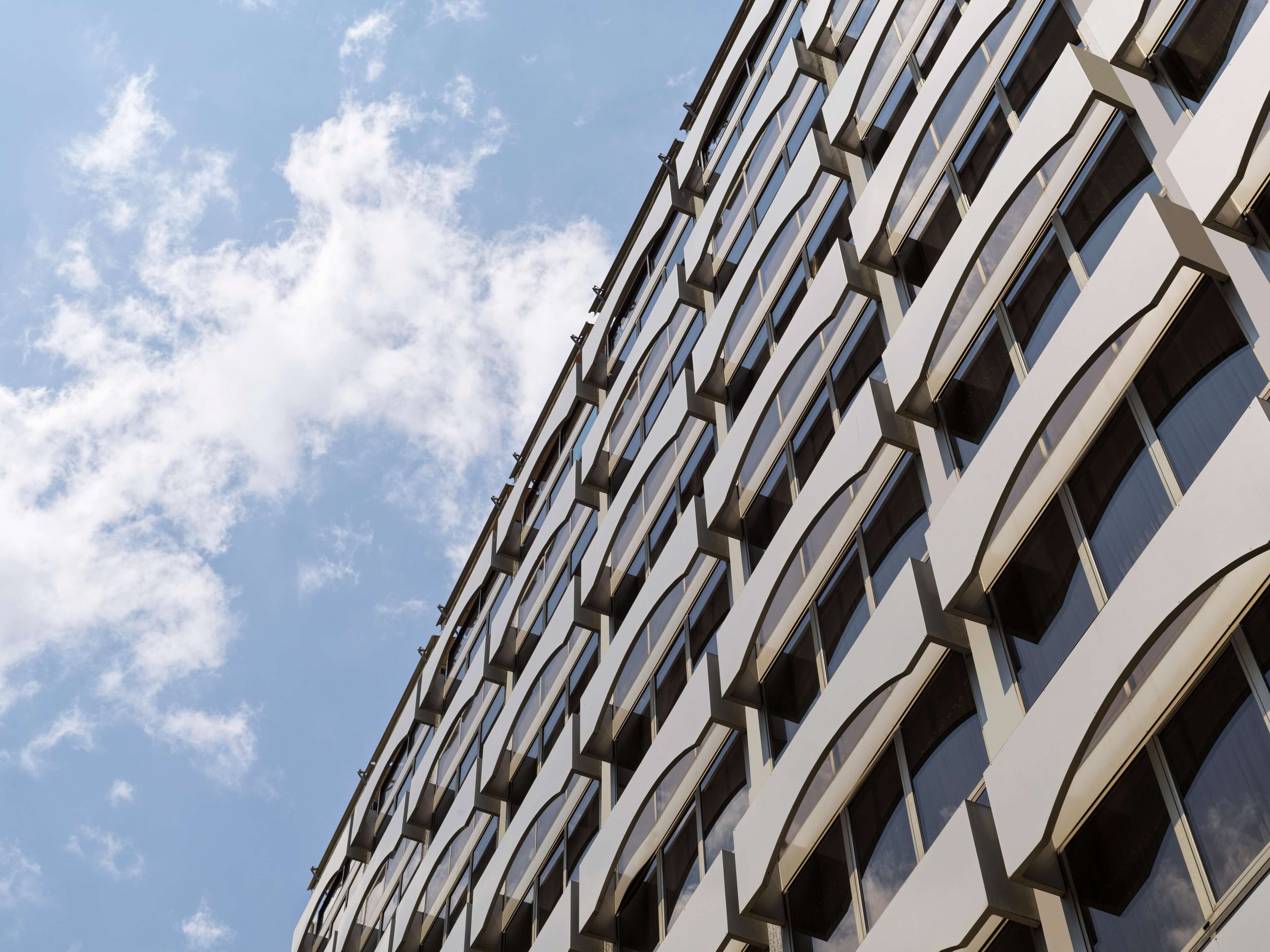 Un edifici modern amb una façana geomètrica repetitiva i nombroses finestres.