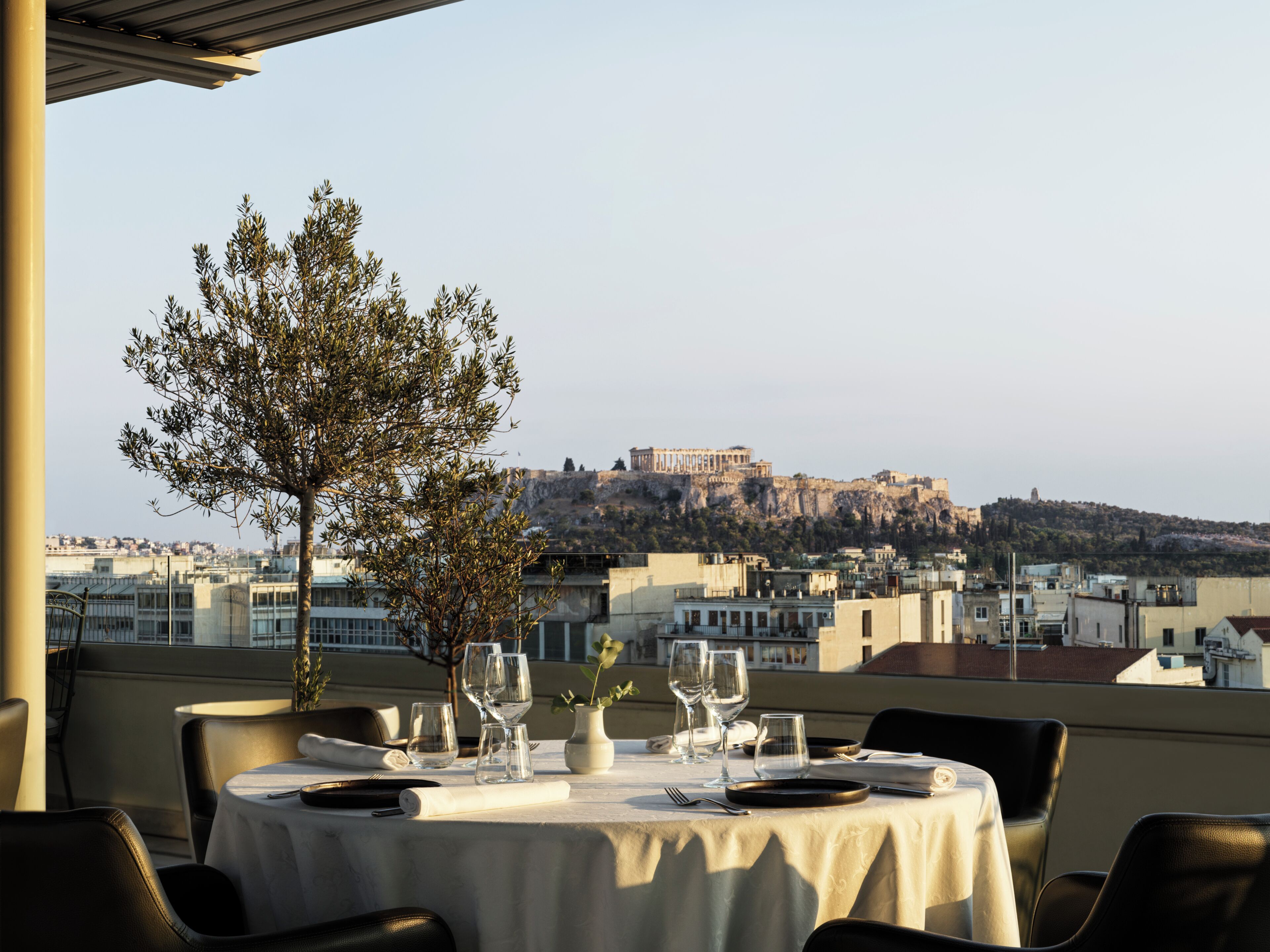 A table set for dining with a view of a historic hilltop fortress.