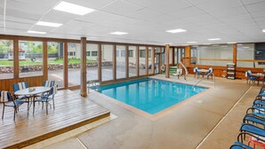 A pool area with a wooden deck, poolside chairs, and a view of the outside. - Quality Inn & Suites Goshen (Goshen)