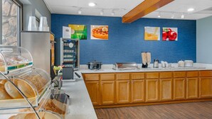 A breakfast bar with a coffee machine, a toaster, and a food display. - Quality Inn & Suites Goshen (Goshen)