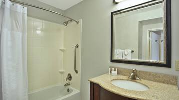 A bathroom with a bathtub, a shower, a sink, and a mirror.