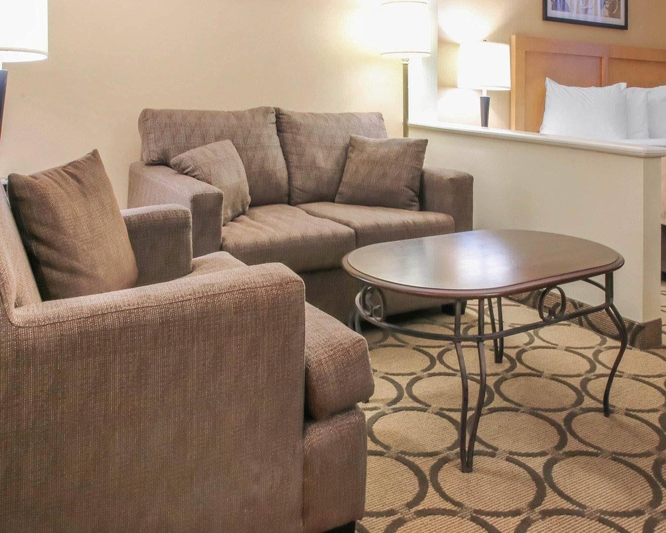 Habitación de hotel con sofá, una mesita y dos lámparas.