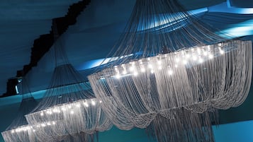 A modern interior with a large, illuminated, geometric chandelier.